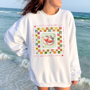 May include: White sweatshirt with a colorful graphic of strawberries on a cake and the text "Oh taste & see that the LORD is good" repeated four times.