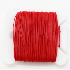 May include: A spool of bright red thread.