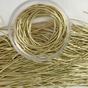 May include: A close-up of a container filled with gold-colored wire. The wire is arranged in a circular pattern and is ready for crafting projects.