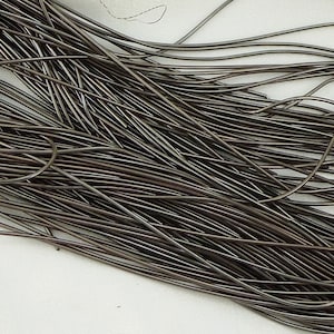 May include: A bundle of dark gray wire, likely used for jewelry making or crafts.