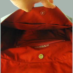 May include: The inside of a red tote bag with a zippered pocket and a small label that says "Handmade".