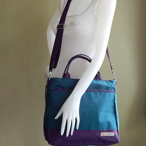 May include: A teal and purple tote bag with a purple shoulder strap and a small logo that says "TinyTote".