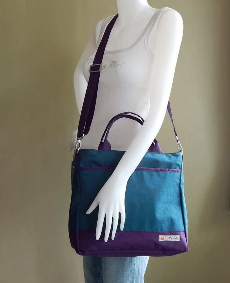 May include: A teal and purple tote bag with a purple shoulder strap and a small logo that says "TinyTote".