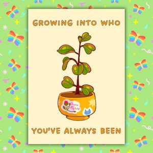 以下が含まれることがあります： 「GROWING INTO WHO YOU'VE ALWAYS BEEN」というテキストが入ったグリーティングカード。カードには、「Trans Rights」のステッカーが付いた黄色の鉢に入った植物の漫画イラストが描かれています。背景は虹色の蝶と星で飾られています。