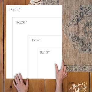 May include: Four white frames with black text showing different sizes: 18x24 inches, 16x20 inches, 11x14 inches, and 8x10 inches. The frames are on a wooden surface with a rug in the background.