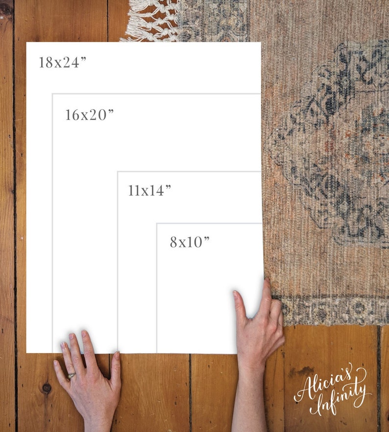 May include: Four white frames with black text showing different sizes: 18x24 inches, 16x20 inches, 11x14 inches, and 8x10 inches. The frames are on a wooden surface with a rug in the background.