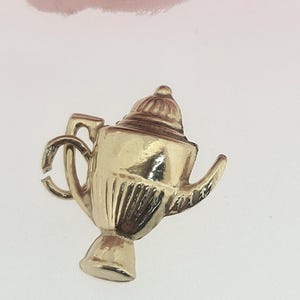 Begagnad vintage berlock med hänge i 9 karat gult guld, ihålig kaffekanna. Vikt 0,7 g, 16 mm x 14 mm.