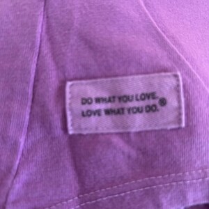 May include: Purple t-shirt with a white tag that reads "Do what you love. Love what you do."