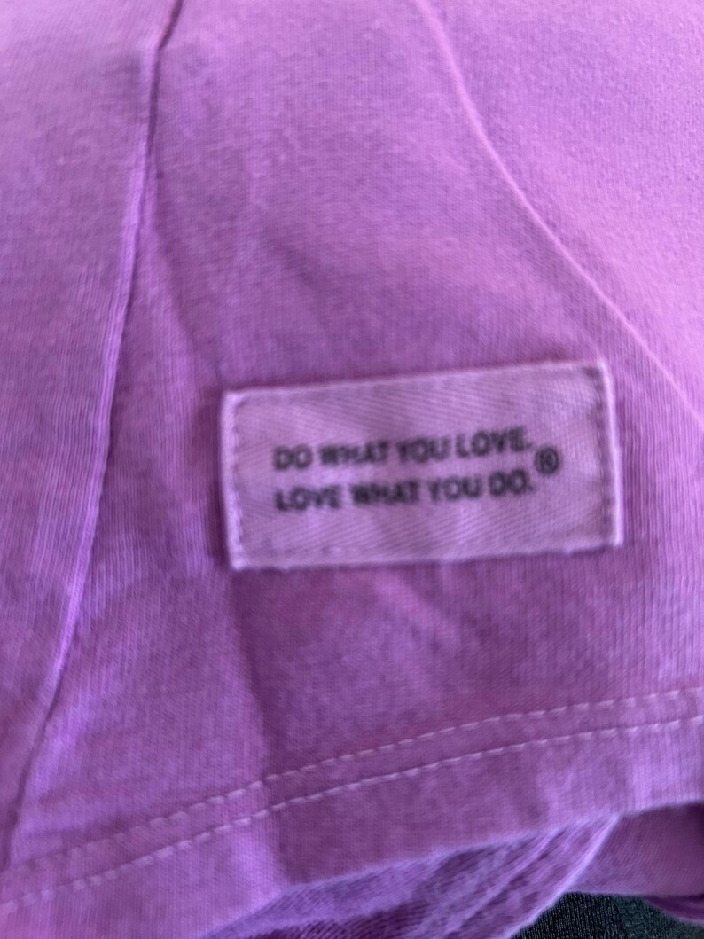 May include: Purple t-shirt with a white tag that reads "Do what you love. Love what you do."