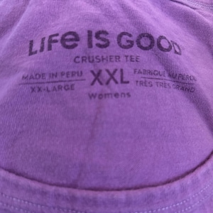 May include: Purple Life is Good crusher tee shirt tag with the text "Made in Peru, XX-Large, XXL, Womens, Fabrique au P&eacute;rou, Tr&egrave;s Tr&egrave;s Grand".