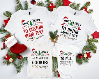 May include: Four white t-shirts with Christmas-themed text. The shirts say "Most Likely To Custom Your Text", "Most Likely To Drink Santa's Beer", "Most Likely To Eat All The Cookies", and "Most Likely To Fall Asleep First".