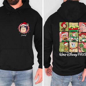Puede incluir: Sudadera con capucha negra con un personaje de dibujos animados con un gorro de Pap&aacute; Noel en la parte delantera, con el nombre "Jeremy" debajo. La parte trasera muestra varios personajes de Toy Story con atuendos navide&ntilde;os, con el texto "Walt Disney World".