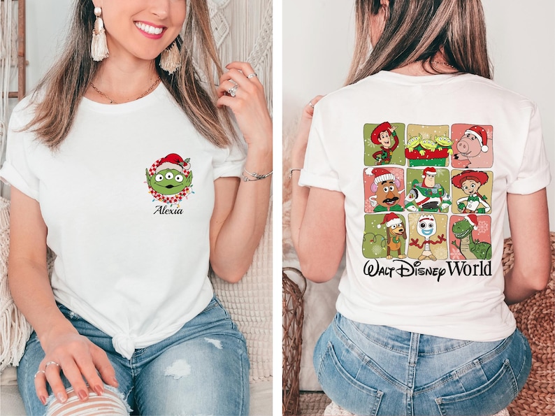 May include: White t-shirt featuring a Christmas-themed Alien character graphic on the front, with the name "Alexia" below. The back of the shirt displays a grid of Toy Story characters in Santa hats, with "Walt Disney World" text.