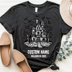 a t-shirt with a Halloween-themed graphic, a hat, and some shoes, all laid out on a white surface.