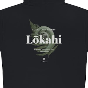 Może przedstawiać: Czarna bluza z kapturem i zamkiem błyskawicznym, z zielonym wzorem paproci i napisem "Lōkahi" w kolorze białym. Napis "Balance Unity Harmony" znajduje się nad słowem "Lōkahi", a napis "Aloha Eia, Aloha No Keia, Aloha No Ka Mea, Aloha No Ke Akua" pod słowem "Lōkahi". Napis "A-Wear" znajduje się na dole wzoru.