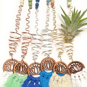 May include: Five hanging plant holders with a wooden lotus flower design and colorful macrame tassels. Each holder features a metal spiral and colorful lava rock beads.