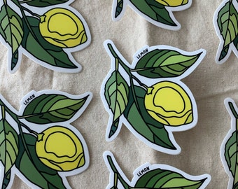 May include: Stickers of lemon branches with yellow lemons and green leaves. Each sticker has the word "LEMON" printed on it. The stickers are on a beige background.