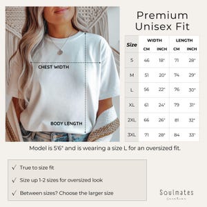 May include: A white t-shirt with a size chart for a premium unisex fit. The chart shows chest width and body length measurements in inches and centimeters. The model is 5'6" and wearing a size L for an oversized fit.