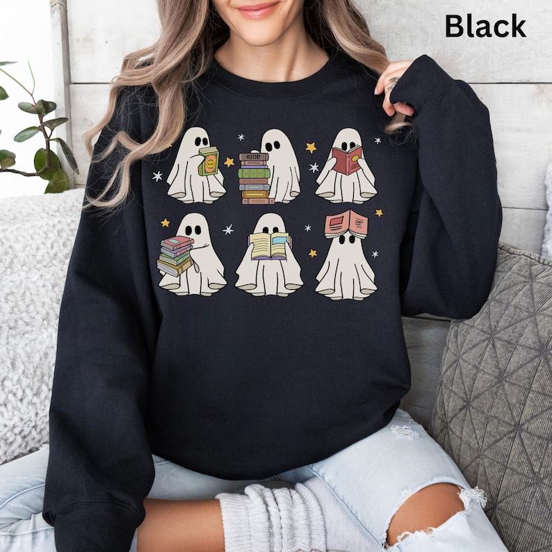May include: Black sweatshirt featuring a graphic of cartoon ghosts reading books. The ghosts are white with black eyes and are holding stacks of books or reading them. The word "Black" is printed in white at the top right.