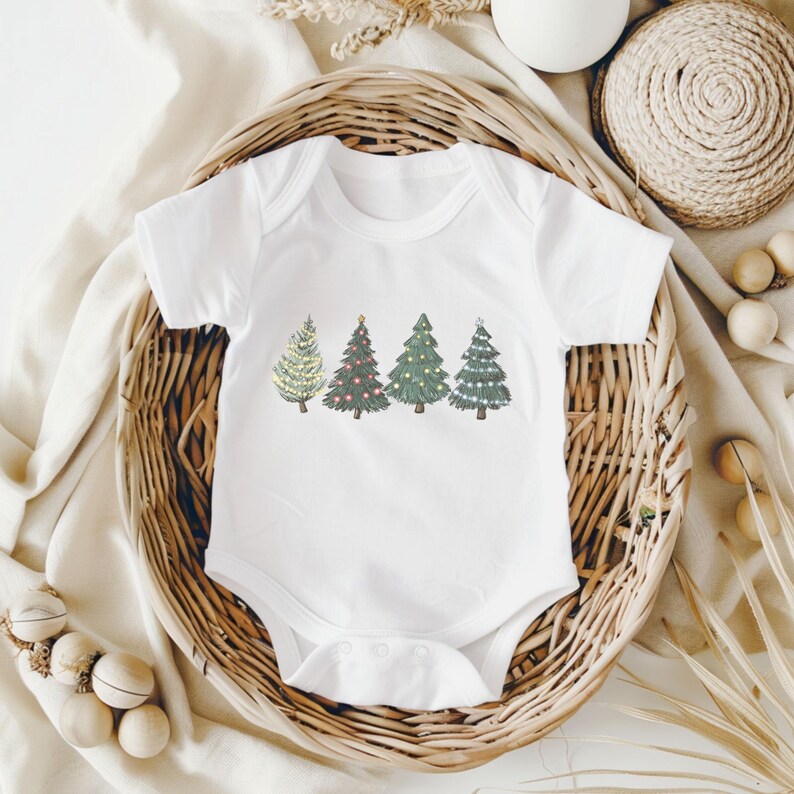 May include: White baby bodysuit with a festive Christmas tree design. The design features four different trees in shades of green, with lights and ornaments. The bodysuit is made of soft material and is perfect for the holiday season.