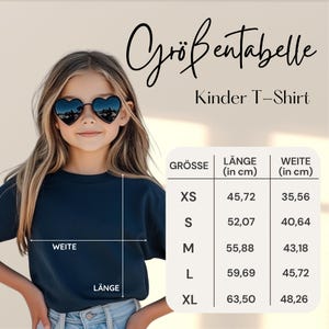 Puede incluir: Una persona joven con una camiseta azul marino y gafas de sol en forma de coraz&oacute;n. La imagen incluye una tabla de tallas en cm para camisetas infantiles, con medidas de largo y ancho.