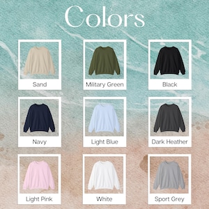 May include: A color chart displaying nine crewneck sweatshirts in various shades including sand, military green, black, navy, light blue, dark heather, light pink, white, and sport grey. Each sweatshirt is presented in a white frame with its color name.