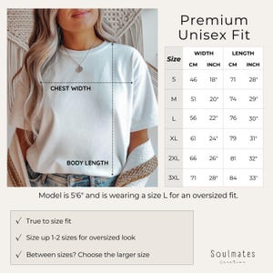 May include: A white t-shirt with a size chart for a premium unisex fit. The chart shows chest width and body length measurements in both centimetres and inches. The model is 5'6" and wearing a size L for an oversized fit.