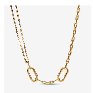 May include: A gold-toned necklace featuring a dual-strand chain on one side that connects to a larger oval link, followed by a short three-link chain segment, and another large oval link that transitions into a single-strand chain on the other side.