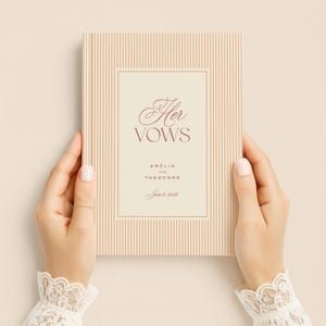 K&ouml;nnte beinhalten: Ein Hochzeitsgel&uuml;bdebuch mit cremefarbenem und pfirsichfarbenem gestreiftem Einband. Das Buch enth&auml;lt die Worte "Her Vows" in burgunderfarbener Schrift, zusammen mit den Namen Amelia und Theodore und dem Datum 6. Juni 2026.