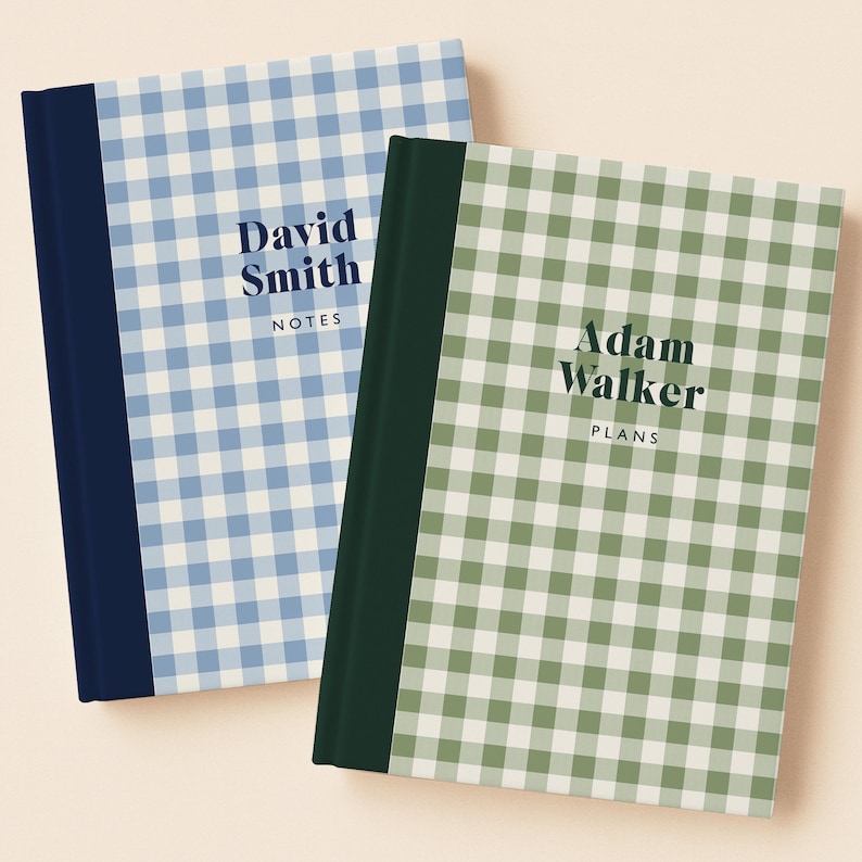 May include: Two hardcover notebooks with a gingham pattern. One is light blue with the text "David Smith NOTES" and a navy blue spine. The other is green with the text "Adam Walker PLANS" and a dark green spine.