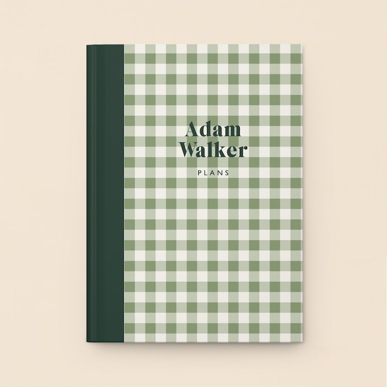 May include: A hardcover notebook with a green and white gingham pattern. The spine is a solid dark green. The text "Adam Walker PLANS" is printed in a dark font on the front cover.