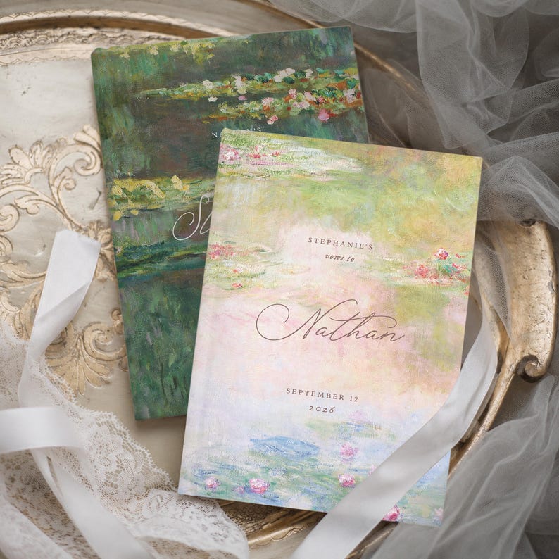 May include: Two rectangular vow books featuring an impressionist water lily painting design in shades of green, pink, and blue. The front book displays the text Stephanie's vows to Nathan and the date September 12, 2026, in elegant black script.