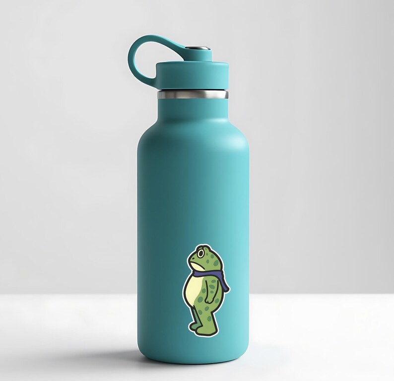 May include: A teal water bottle with a black lid and handle. A sticker of a cartoon frog wearing a purple scarf is on the front. The frog is green with yellow accents and a sad expression.