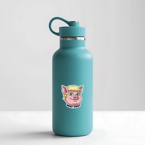 May include: A teal insulated water bottle with a black handle and a silver rim. A sticker of a cartoon pig with blonde hair and the text "QUIET PIGGY" is on the front.