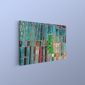 May include: A colorful abstract mosaic artwork with a variety of blue, green, red, and yellow glass pieces. The mosaic is framed and ready to hang on a wall.