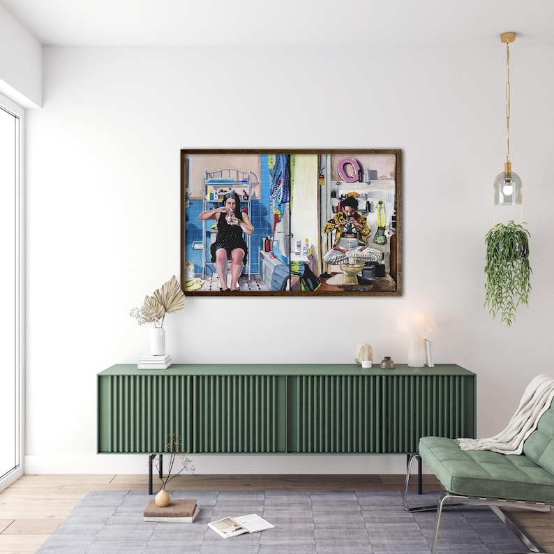 May include: A framed painting depicting two people in separate bathroom settings. The person on the left is a woman with long dark hair, wearing a black dress, sitting on a toilet and holding a phone. The person on the right is a man with a beard, wearing a yellow shirt and a blue hat, sitting on a toilet and holding a phone. The painting is set against a white wall with a green cabinet underneath.