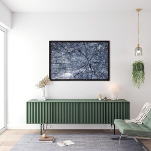 Könnte beinhalten: Ein gerahmtes Foto eines Baumstammquerschnitts mit einem blauen und grauen Farbschema. Das Foto hängt an einer weißen Wand über einem grünen Schrank mit einem hellen Holzboden.