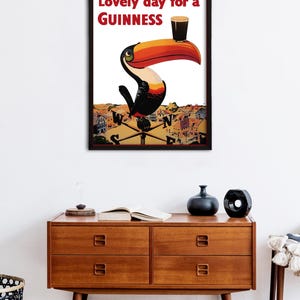 May include: A vintage Guinness advertisement featuring a toucan holding a glass of Guinness with the text "Lovely day for a GUINNESS".