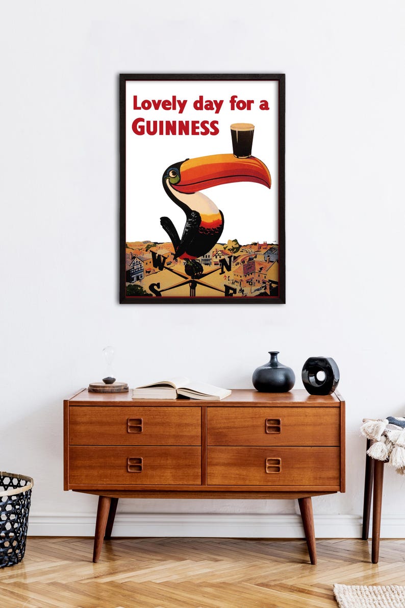 May include: A vintage Guinness advertisement featuring a toucan holding a glass of Guinness with the text "Lovely day for a GUINNESS".