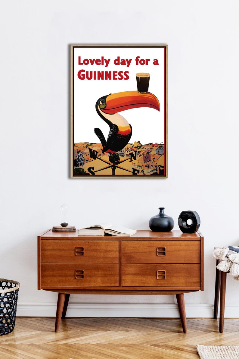 May include: A vintage Guinness advertisement featuring a toucan holding a glass of Guinness with the text "Lovely day for a GUINNESS".