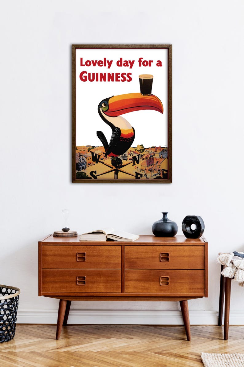 May include: A vintage Guinness advertisement featuring a toucan holding a glass of Guinness with the text "Lovely day for a GUINNESS".