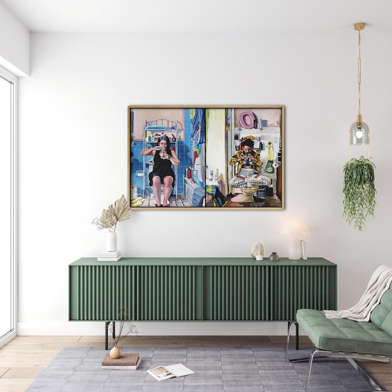 May include: A framed painting depicting two people in a bathroom setting. The painting is in a gold frame and is hanging on a white wall above a green cabinet. The painting is divided into two sections, with the left side showing a woman sitting on a toilet and the right side showing a man sitting on a toilet.