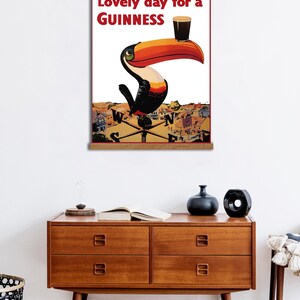 May include: A vintage Guinness advertisement featuring a toucan holding a glass of Guinness with the text "Lovely day for a GUINNESS".