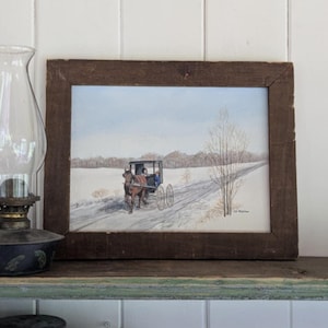 Pintura Amish vintage de C.S. Milliken: Madre e hijo en una carreta tirada por caballos, paisaje nevado. Óleo/acrílico original, marco rústico, 38 x 29 cm.