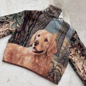May include: A tapestry jacket with a Golden Retriever design set in a forest. The jacket has a high collar and long sleeves. The colour scheme includes browns, greens, and tans.