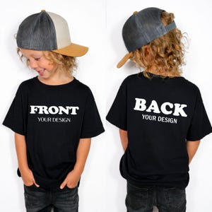 A young child wearing a black t-shirt with the text "FRONT YOUR DESIGN" and a gray baseball cap, smiling at the camera.
