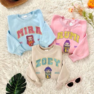 Band Huntrix Embroidered Youth Sweatshirt, Kpop Huntrix Tee, Rumi Zoey Mira Derpy, Demon Hunters Family Shirt, Gift For Fans ESH5265-5267