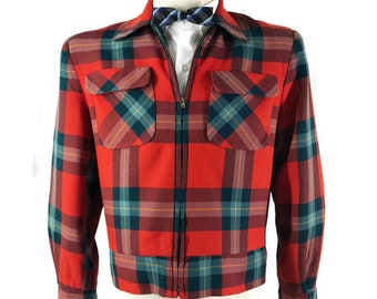 May include: A red, green, and blue plaid jacket with a zipper closure and two front pockets. The jacket is displayed on a mannequin and paired with a white shirt and a patterned bow tie. The jacket has a collared neckline.
