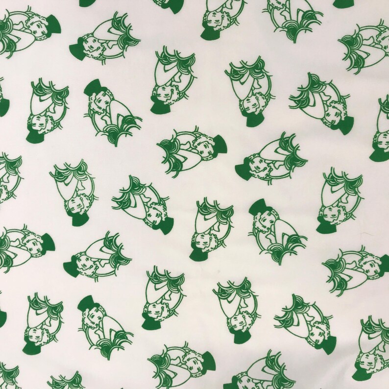 May include: White fabric featuring a repeating pattern of green illustrations. Each illustration shows a person seated, wearing a hat and surrounded by stylized foliage. The design is evenly spaced across the fabric.