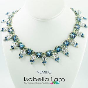 Peut inclure: Un collier délicat en perles avec un schéma de couleurs argent, bleu et vert. Le collier présente un motif répétitif de petites perles et de perles plus grandes et facettées. Le collier est présenté sur un buste de mannequin blanc.